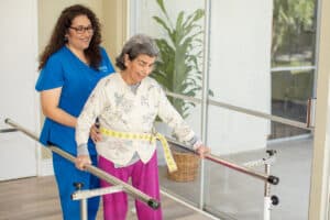 Rehab therapist helping resident in the gym